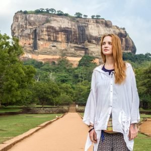 Beautiful girl and Sigiriya Rock (Lion Rock) is an ancient fortress near Dambulla, Sri Lanka